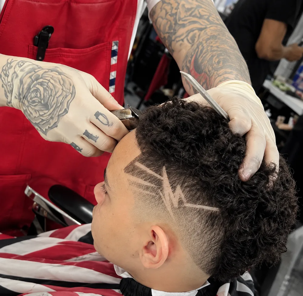 Ace of Fadezz carving a freehand lightning design with a fade